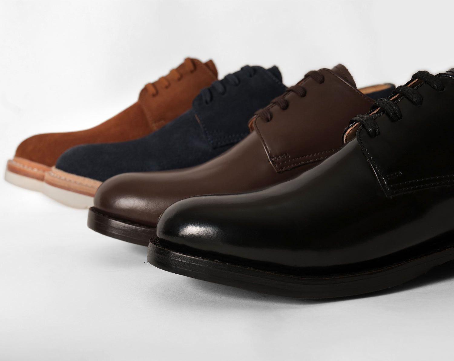 Blucher shoes arranged horizontally showcasing simple design and solid classic colors