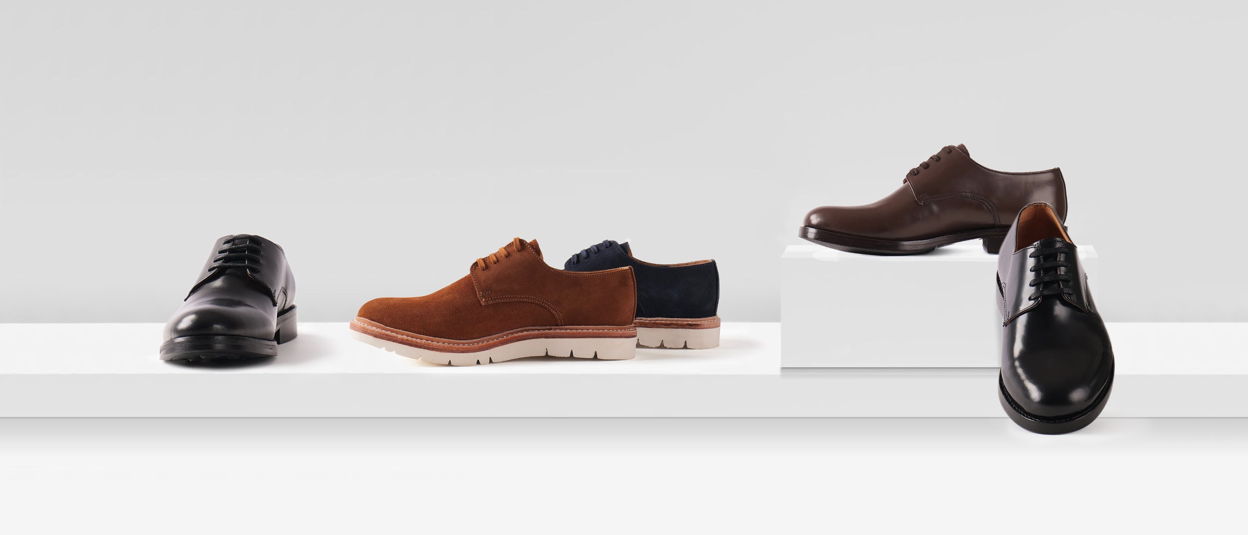 Handcrafted leather Blucher shoes collection displayed on a white studio table